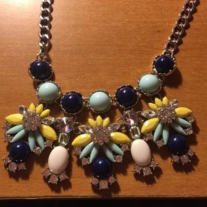 A silver statement necklace with mint and navy.